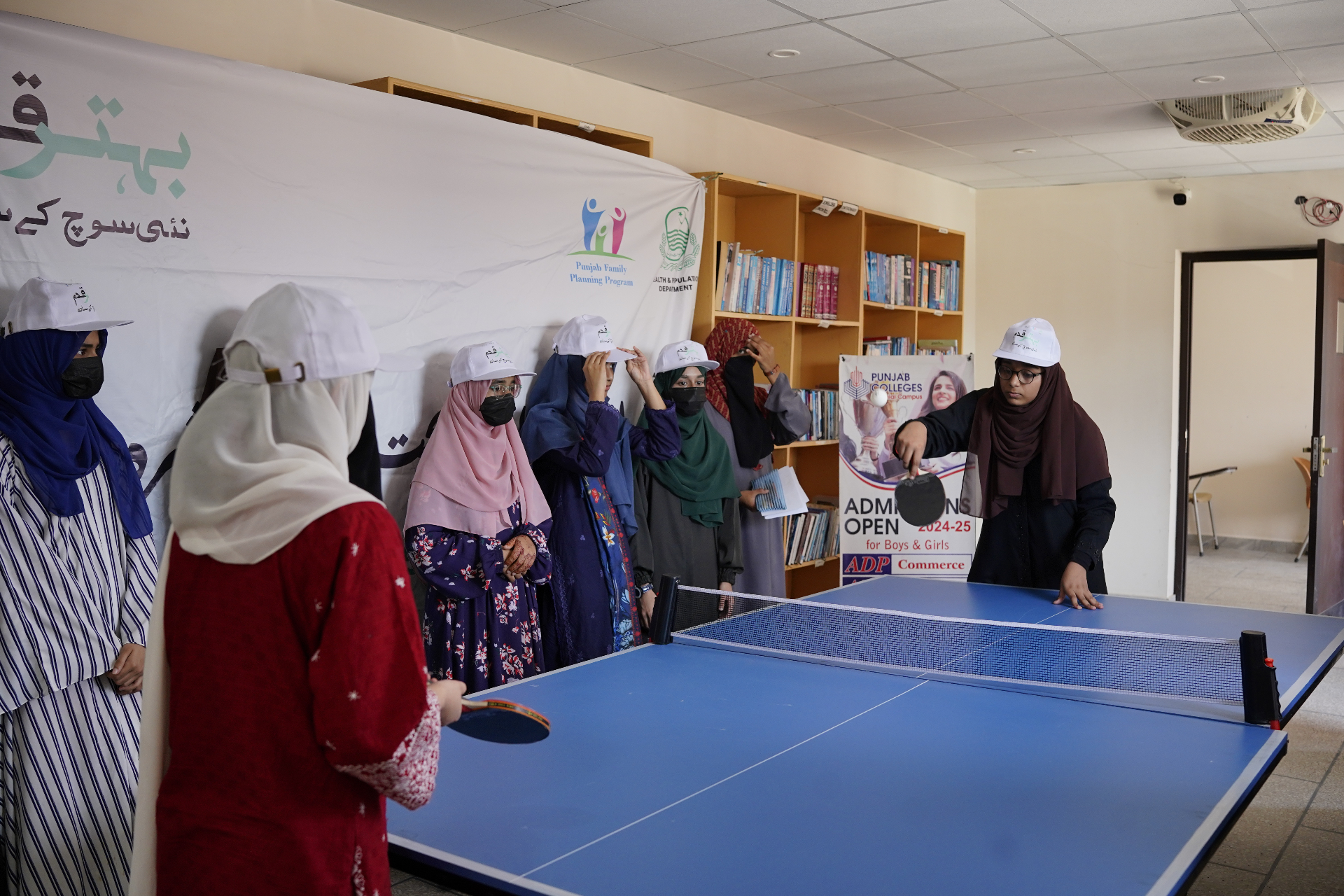 Young women engaged in a table tennis activity at a Punjab Family Planning Program event